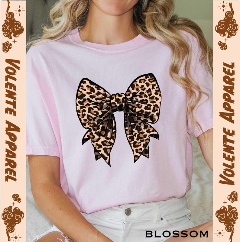 a woman wearing a pink shirt with a leopard print bow