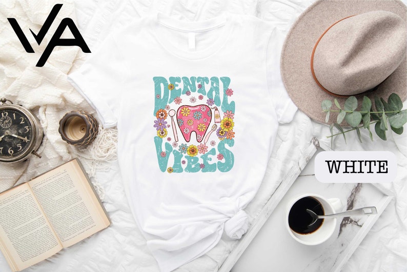 a white shirt with a pink tooth and flowers on it