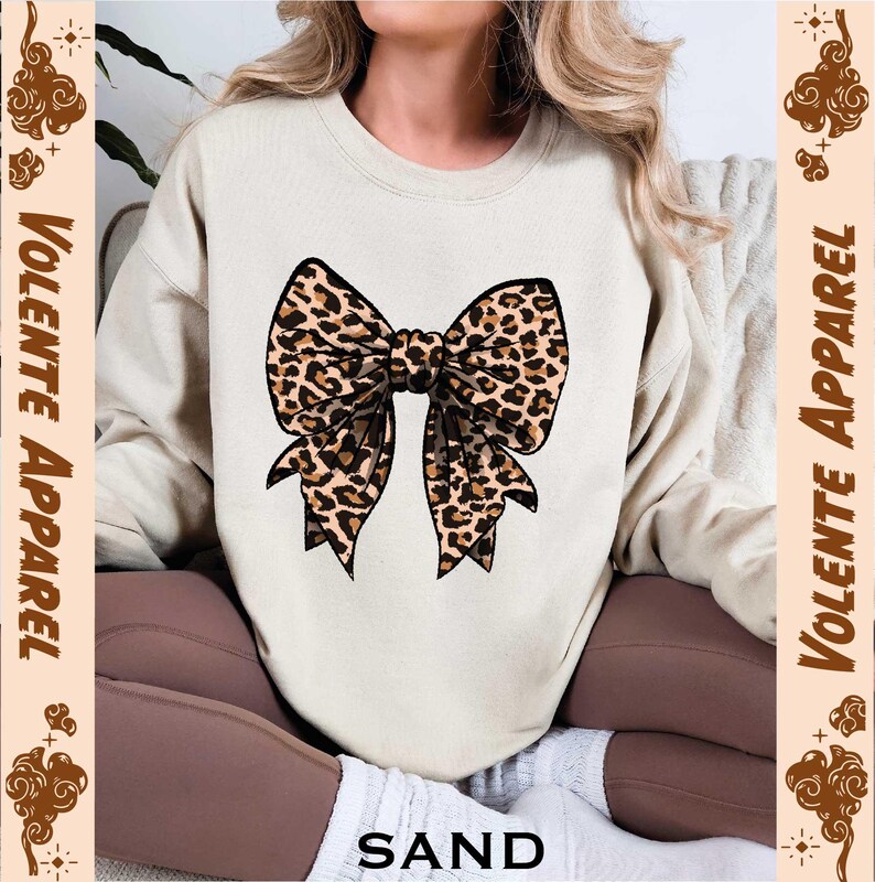 a woman wearing a sweater with a leopard print bow on it