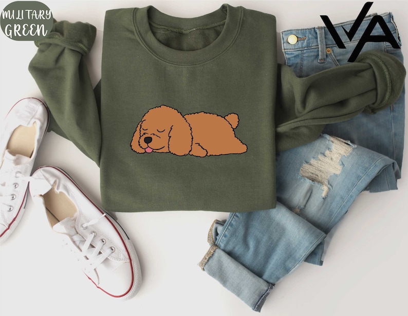 a brown dog laying on top of a green shirt