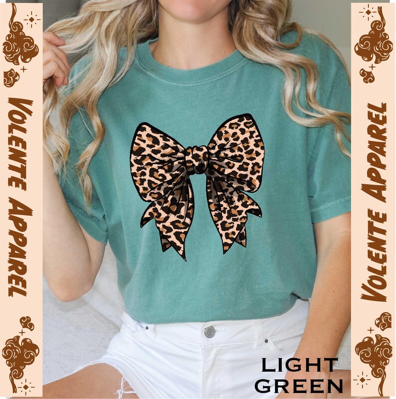 a woman wearing a green shirt with a leopard bow on it