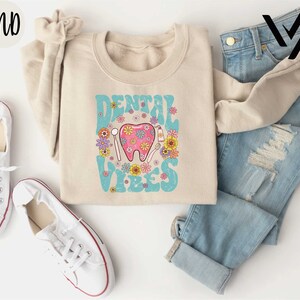 a pair of jeans and a sweater with a pink elephant on it