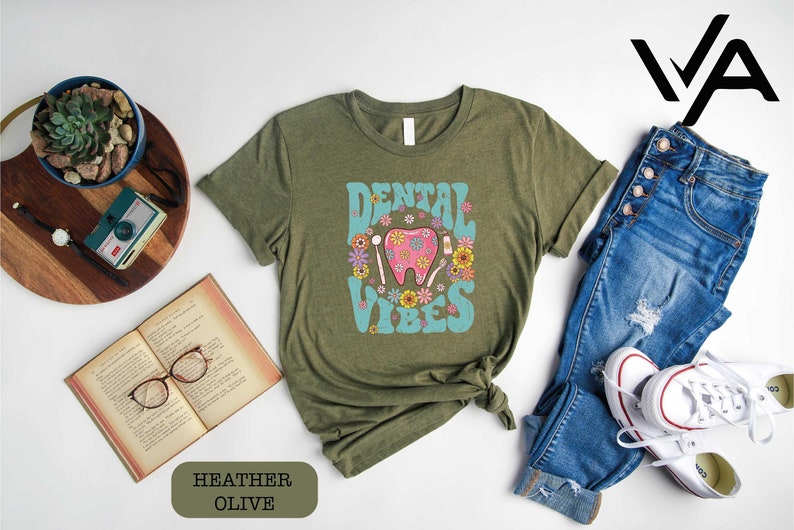 a shirt that says dental vibes on it next to a pair of jeans and