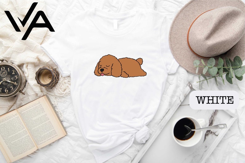 a brown dog laying on top of a white shirt