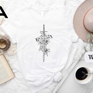 a white shirt with a cross and flowers on it