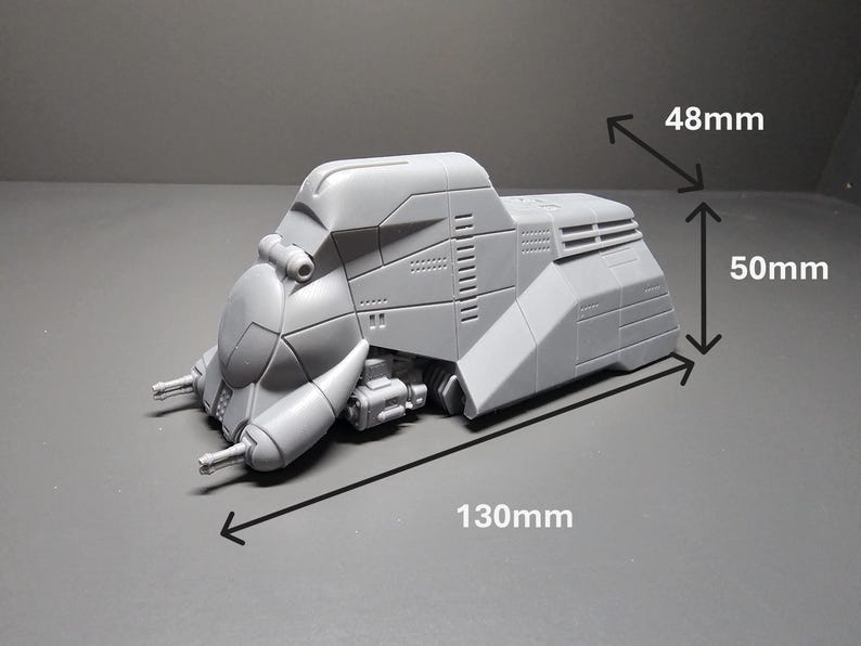 May include: A gray, futuristic model of a vehicle, measuring 130mm long, 50mm high, and 48mm wide. The model has a detailed design with various panels, vents, and protrusions, suggesting a sci-fi or military theme.