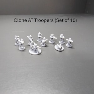 May include: A set of ten grey Clone AT Troopers miniature figures. Each figure is posed with a weapon, standing on a circular base. The text "Clone AT Troopers (Set of 10)" is above the figures.