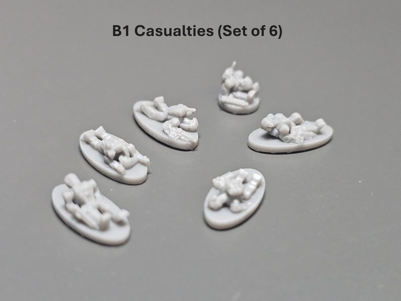 K&ouml;nnte beinhalten: Set mit sechs grauen Miniatur-Opfern, jeweils auf einer kleinen ovalen Basis. Der Text "B1 Casualties (Set of 6)" steht oben. Diese Miniaturen sind wahrscheinlich f&uuml;r ein Tabletop-Spiel.