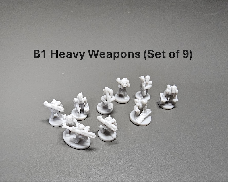 K&ouml;nnte beinhalten: Ein Set aus neun kleinen, grauen B1 Heavy Weapons Miniaturen. Jede Miniatur hat ein einzigartiges Design mit verschiedenen Waffenaufs&auml;tzen. Der Text "B1 Heavy Weapons (Set of 9)" ist oben im Bild zu sehen.