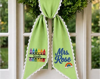 Banda personalizada para maestra, lazo bordado de manzana y crayón para la puerta con motivo de la vuelta al cole.