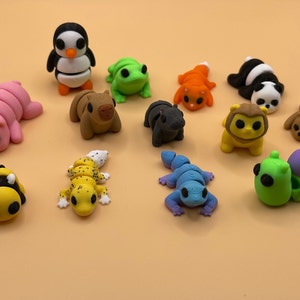 K&ouml;nnte beinhalten: Eine Sammlung von 14 kleinen, bunten Tierfiguren, darunter ein Pinguin, ein Frosch, eine Raupe, eine Biene, ein Gecko und eine Schnecke. Die Figuren sind aus Kunststoff und etwa 5 cm gro&szlig;.