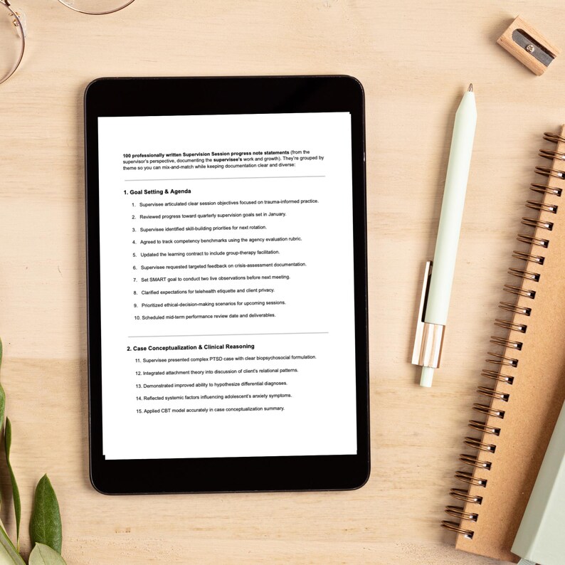May include: A black tablet displaying a document with text about supervision sessions, a white pen, a spiral notebook, and a pencil sharpener are on a light wooden surface. The tablet's screen shows a list of goals and agenda items.