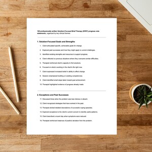 K&ouml;nnte beinhalten: Ein wei&szlig;es Dokument mit Text &uuml;ber Fortschrittsnotizen zur l&ouml;sungsorientierten Kurztherapie (SFBT) liegt auf einer Holzoberfl&auml;che. Das Dokument enth&auml;lt nummerierte Listen mit Zielen, St&auml;rken und vergangenen Erfolgen. Zwei Bleistifte und eine kleine Topfpflanze sind ebenfalls sichtbar.