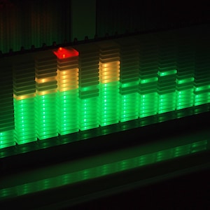 May include: A green and yellow LED light bar with multiple levels of lights. The lights are arranged in a vertical pattern, with the tallest level being yellow and the rest being green.