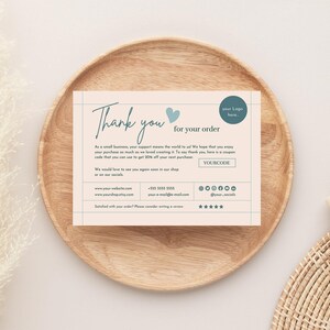 Könnte beinhalten: Eine Dankeskarte mit dem Text "Thank you for your order" in handschriftlichem Stil. Die Karte hat einen hellbeigen Hintergrund mit einem blauen Herz und Platz für ein Logo. Die Karte liegt auf einem Holztablett.