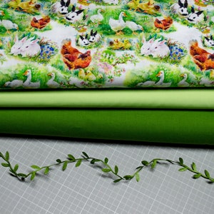 Könnte beinhalten: Drei Stoffstücke, eines mit weißem Hintergrund und einem sich wiederholenden Muster aus Gänsen, Kaninchen, Küken und Hühnern, eines hellgrün und eines dunkelgrün.