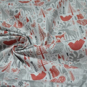 May include: White fabric featuring a repeating pattern of red and grey woodland creatures, trees, and hearts. The design includes foxes, birds, owls, and deer. The fabric is folded, showing the texture and detail of the print.