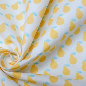 May include: White fabric with a repeating pattern of yellow pears with green leaves. The fabric is folded and twisted.
