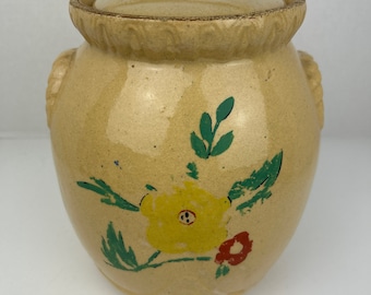 Vintage painted glazed crock cookie jar with lid. Light gold color with hand painted yellow and red flowers with green leaves.