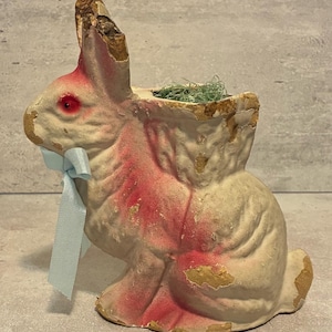 May include: A white ceramic mug with a black handle and the text "But First, Coffee" in a bold, black font. The mug is sitting on a wooden surface. The mug is approximately 4 inches tall.