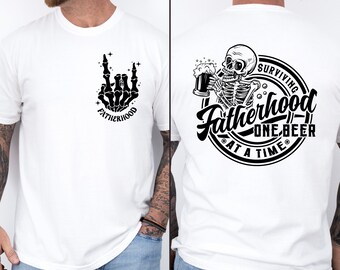 Può includere: T-shirt bianco con grafica nera. Sul davanti, una mano di scheletro che fa il gesto rock and roll, con la parola "FATHERHOOD" sotto. Il retro presenta uno scheletro che beve birra con la scritta "SURVIVING FATHERHOOD ONE BEER AT A TIME."