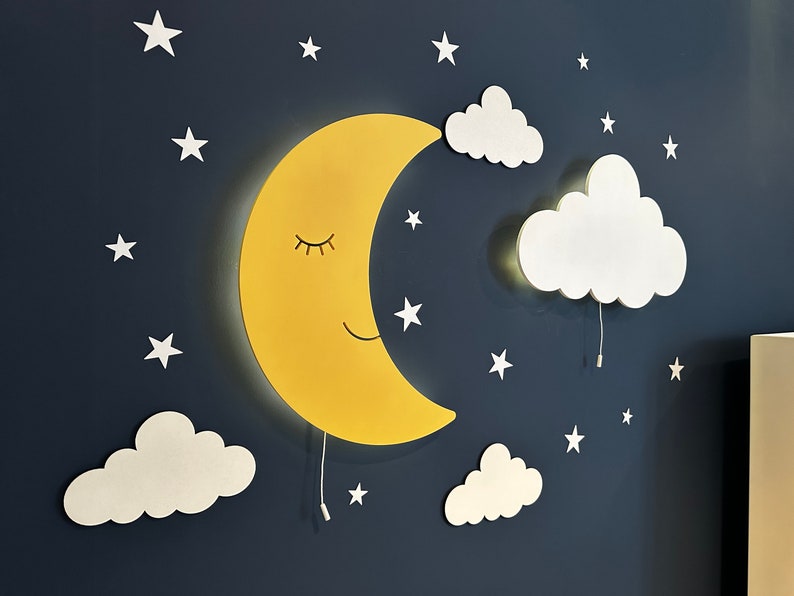 May include: A yellow crescent moon wall light with a smiling face and closed eyes, surrounded by white clouds and stars on a dark blue background.