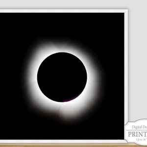 May include: A black and white photograph of a total solar eclipse. The sun is completely blocked by the moon, creating a bright ring of light around the dark silhouette of the moon.