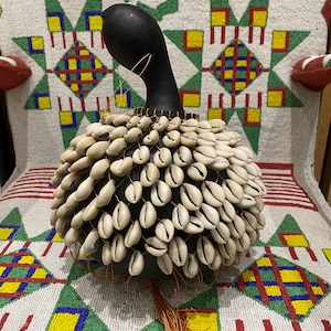 Shekere africano, shaker/ ichaka Instrumento musical africano de concha de cauri Sonajero africano/ maracas Instrumento tradicional de Nigeria y Ghana