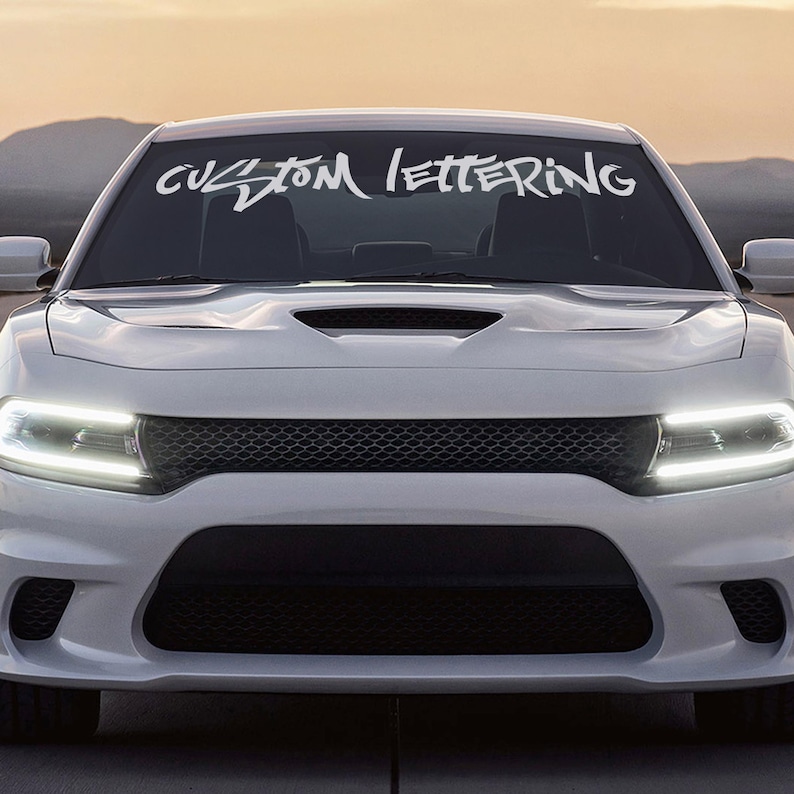 May include: White car with a custom lettering decal on the windshield that says "CUSTOM LETTERING".