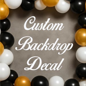 May include: A custom backdrop decal with the words "Custom Backdrop Decal" in white script. The text is centered on a gray background and surrounded by a border of black, white, and gold balloons.