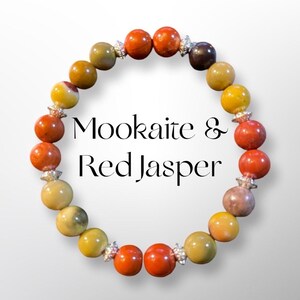 May include: A bracelet made with red jasper and mookaite beads. The beads are separated by silver spacers. The bracelet is on a white background.