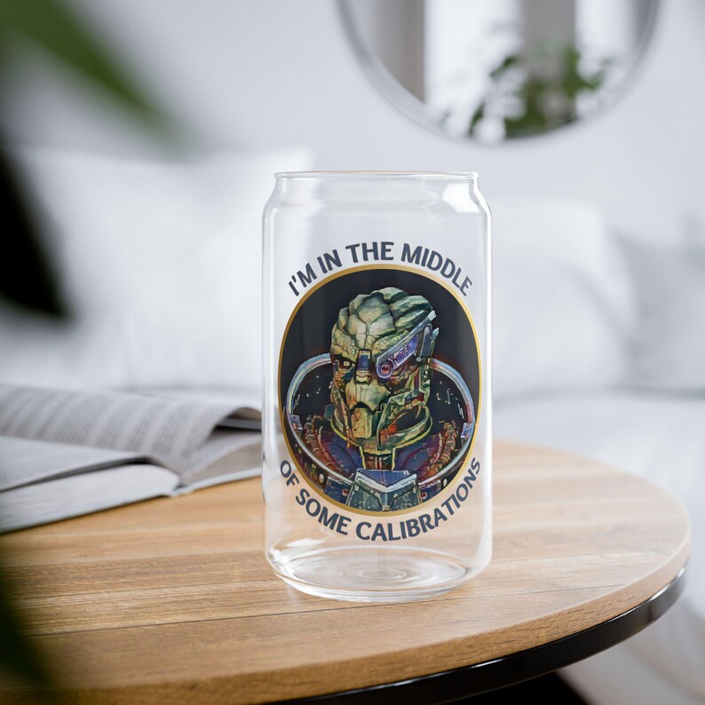 A 16oz clear glass with a stylized image of Garrus from Mass Effect, framed in a circle with the quote “I’m in the middle of some calibrations” in bold, sci-fi inspired font.