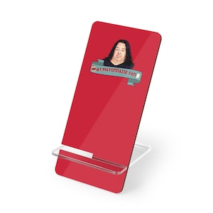 May include: Red phone stand with a white stand and a picture of a man with the text "#1 Mayonnaise Fan" on it.