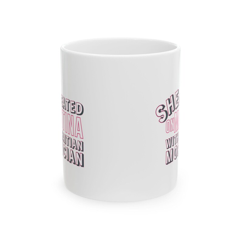 White ceramic mug with bold pink and black text reading “She cheated on Martina with a Haitian mortician,” referencing a Real Housewives of Miami quote.