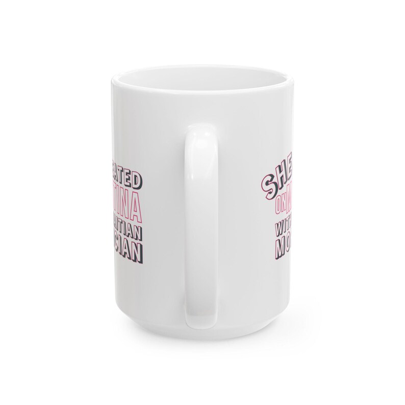 White ceramic mug with bold pink and black text reading “She cheated on Martina with a Haitian mortician,” referencing a Real Housewives of Miami quote.