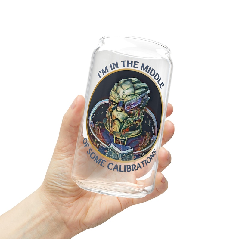 A 16oz clear glass with a stylized image of Garrus from Mass Effect, framed in a circle with the quote “I’m in the middle of some calibrations” in bold, sci-fi inspired font.