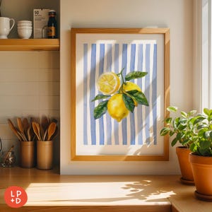 May include: A framed watercolor print featuring a lemon branch with bright yellow lemons and green leaves against a blue and white striped background. The artwork is displayed in a light wood frame, suitable for kitchen or dining room decor.
