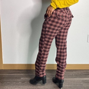 May include: Red and black checked trousers with a straight leg fit. The trousers are made from a soft, comfortable fabric and have a relaxed fit.