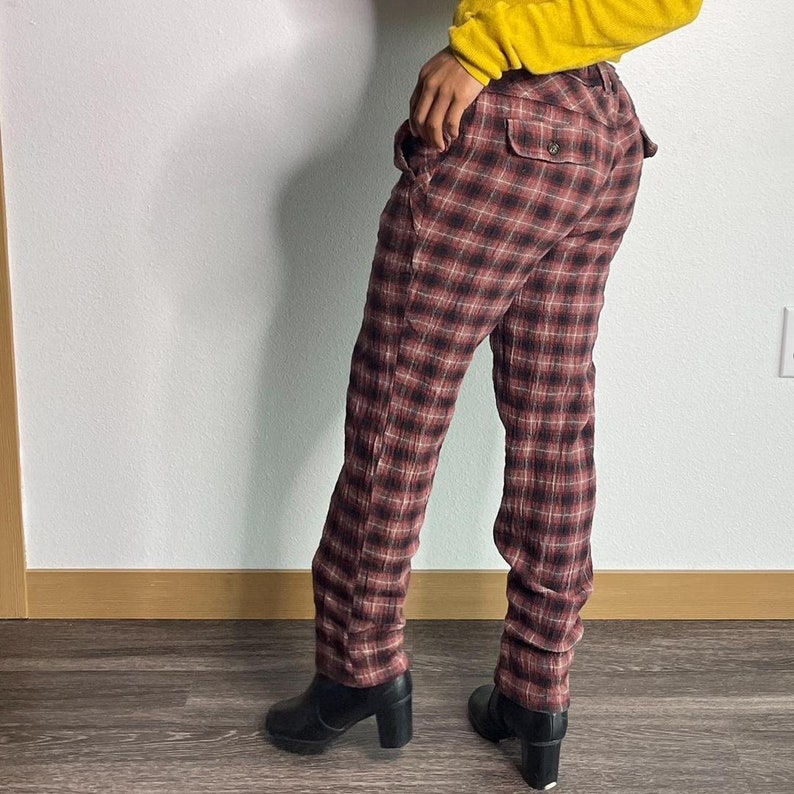 May include: Red and black checked trousers with a straight leg fit. The trousers are made from a soft, comfortable fabric and have a relaxed fit.