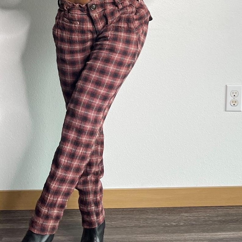 May include: Red and black checked trousers with a high waist and a relaxed fit.