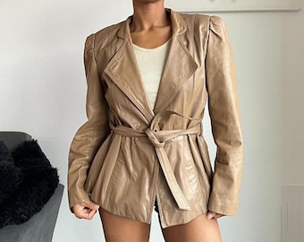 Könnte beinhalten: Eine braune Lederjacke mit Gürtelbund und leicht bauschigen Schultern.