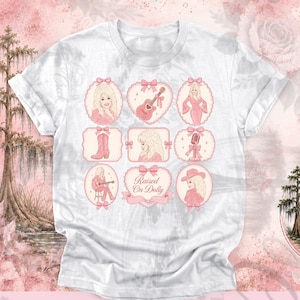 Puede incluir: Una camiseta blanca con una cuadrícula de nueve ilustraciones en tonos rosas que incluyen una figura rubia, una guitarra, una bota vaquera, un micrófono y un emblema en forma de corazón con el texto Raised On Dolly, decorado con lazos.