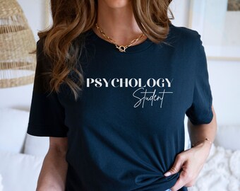 May include: A dark blue t-shirt with the text "Psychology Student" in white lettering. The text "Psychology" is in a bold, sans-serif font, while "Student" is in a cursive script font.