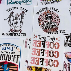 May include: A collection of white paper sheets with various printed designs. Designs include a margarita, skeletons, the text "I hate everyone but coffee", and the word "coffee" in multiple colors. The overall theme is humorous and lifestyle-oriented.
