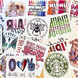 May include: A collection of various printed designs on white paper. The designs include text, illustrations, and logos. Some feature phrases like "Anti-Social" and "Feeling Lucky." Others showcase a bee, a fairy, and a Starbucks logo.