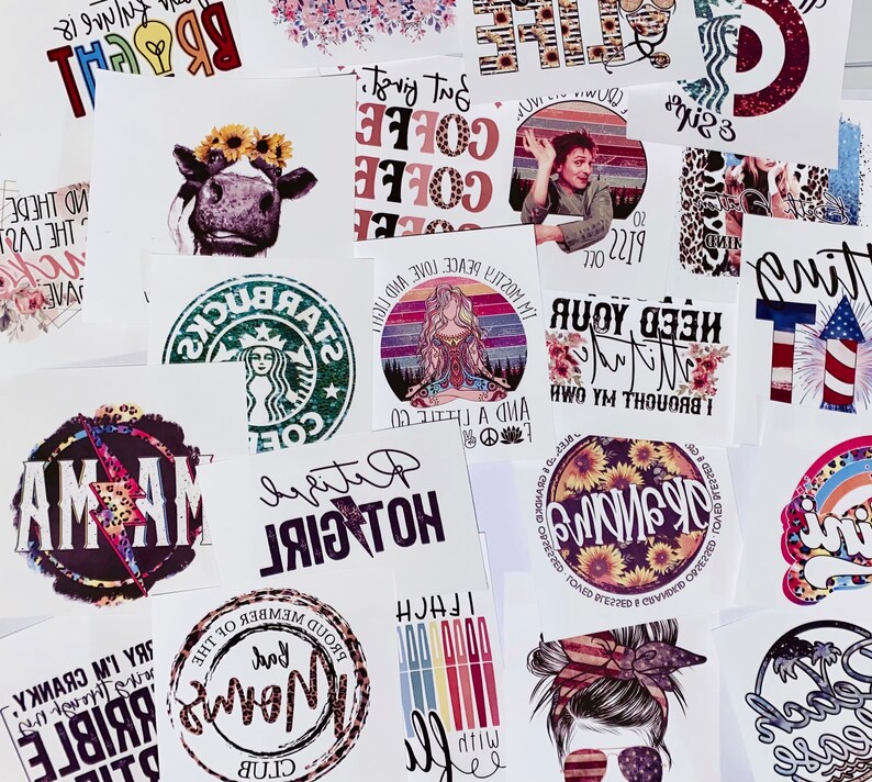 May include: A collection of various printed designs on white paper. The designs include a cow with a sunflower crown, coffee-themed text, a Starbucks logo, and a woman meditating. Other designs feature text like "MAMA" and "HOT GIRL".
