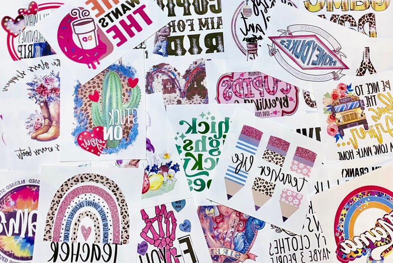 May include: A collection of colorful stickers with various designs and text. Designs include a cactus with a heart, a coffee cup, a rainbow, and pencils. Text includes "Teacher", "Sick", and "The Heart Wants What It Wants".