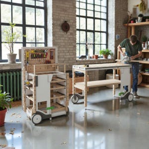 Op de afbeelding: Een werkplaats met een mobiele gereedschapskar en een werkbank met wielen. De gereedschapskar heeft planken en een pegboard voor gereedschap. Een persoon gebruikt een bovenfrees op de werkbank. De werkplaats is goed verlicht.