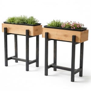 Könnte beinhalten: Zwei Holzpflanzkästen mit schwarzen Metallbeinen. Jeder Pflanzkasten enthält Grün und Blumen. Die Holzkästen sind hellbraun und die Metallbeine sind schwarz. Die Pflanzkästen sind erhöht, geeignet für eine Terrasse oder einen Garten.
