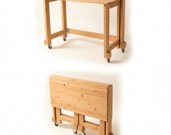 May include: A light-coloured wooden folding table with a rectangular top and four legs. The table is on wheels for easy movement. The table is shown both fully extended and folded.